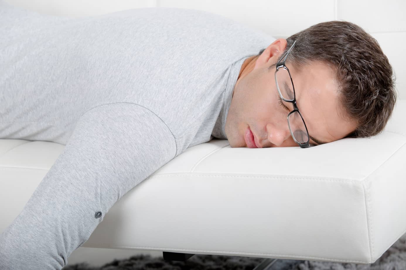 close up of a man sleeping on sofa due to COVID